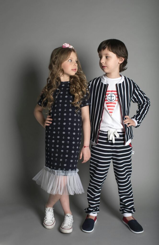 pexels-photo-1620788-1620788 Two children in stylish nautical-themed clothing posing confidently in a studio.